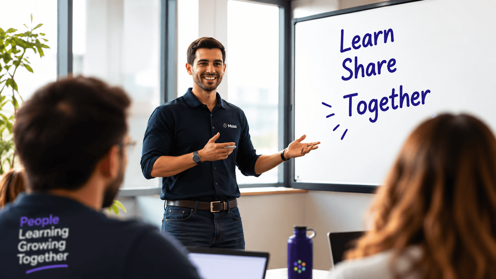 A trainer leading a workplace learning session beside a whiteboard.