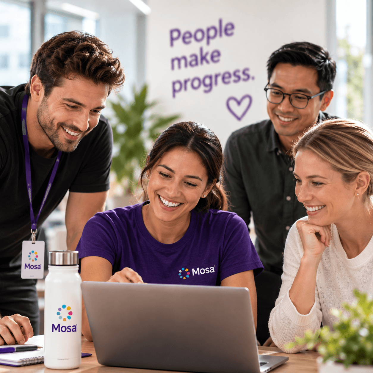 A small workplace team collaborating around a laptop.